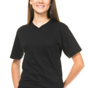 En ung kvinde iført en sort T-shirt og blå jeans smiler til kameraet. Hun står oprejst med hænderne i hoftesiden på en hvid baggrund.