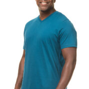 En mand i en blå T-shirt smiler, mens han står oprejst mod en hvid baggrund.