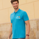 Mand iført en lyseblå polo med teksten "Dit Design" går foran en beige murstensvæg, med et venligt smil. Han bærer jeans og armbånd på håndleddet.