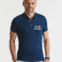 Mand står stille, iført en mørkeblå poloshirt med logoet "ING" på brystet. Han befinder sig i et neutralt, lyst rum uden andre tydelige genstande eller baggrundselementer.