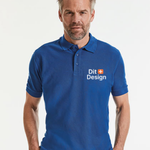 Mand står iført en blå polo-shirt med teksten "Dit Design" og et lille orange og hvidt ikon på brystet. Baggrunden er hvid.