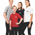 Fire unge personer står sammen iført farvede polo-shirts med teksten "Dit Design". De ser glade ud og befinder sig i et neutralt, hvidt studieomgivelser.