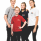 Fire unge personer står sammen iført farvede polo-shirts med teksten "Dit Design". De ser glade ud og befinder sig i et neutralt, hvidt studieomgivelser.