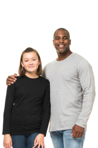 To personer står tæt sammen og smiler; en ung person i en sort trøje og en ældre person i en grå trøje. Baggrunden er hvid.