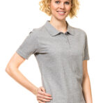 Person, der smiler, iført grå polo t-shirt og blå jeans, står med højre hånd i siden på en hvid baggrund.