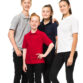 Fire unge personer poserer sammen, iført farverige polo shirts og sorte bukser, står på en hvid baggrund. Ingen tekst ses i billedet.