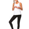 Person står smilende, iført en hvid tank top, sorte leggings og sorte sko på hvid baggrund. Skødesløs fletning hænger over hendes skulder.