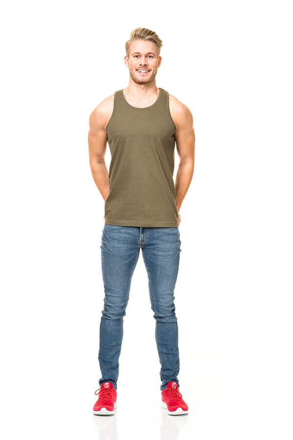 Pragh Undertrøje grøn Mand med grøn tanktop og jeans står smilende med hænderne bag ryggen på en hvid baggrund. Han har røde sneakers på.