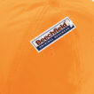En orange kasket med et firkantet mærke fastgjort på toppen. Mærket viser teksten "Beechfield - Original Headwear."