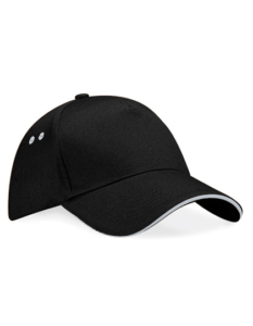 Sort baseballkasket ligger på en hvid overflade. Kasketten har to ventilationshuller på hver side og en buet skygge med hvid kant.