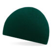 En mørkegrøn, ribstrikket beanie-hue ligger skråt på en hvid baggrund uden andre genstande.