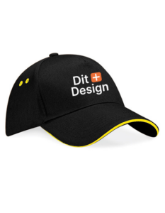 Sort kasket med teksten "Dit Design" og et orange plus-tegn på forsiden. Kasketten har gule detaljer på skyggen og ventilationshullerne.