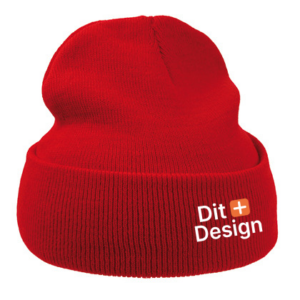 Rød strikhue med foldet kant; teksten "Dit Design" er trykt på forsiden i hvid med et orange plus-symbol. Baggrunden er hvid og enkel.