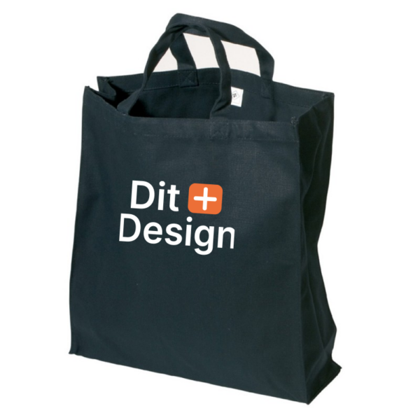 Sort stofpose står oprejst med to håndtag. Teksten "Dit Design" er trykt på forsiden, omgivet af en hvid baggrund og et orange plus-symbol.