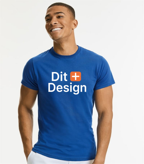 Mand iført en blå T-shirt står og smiler; teksten på T-shirten lyder "Dit + Design" i hvid og orange. Han står imod en hvid baggrund.