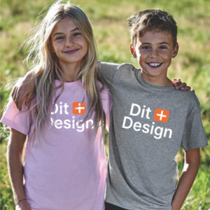 To børn står sammen, den ene med armen om den anden, iført T-shirts med teksten "OK Design". De befinder sig udendørs på en græsmark.