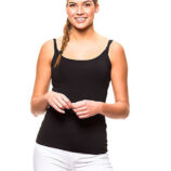 En kvinde med en fletning iført en sort tanktop og hvide bukser, står smilende og holder hænderne sammen foran sig mod en hvid baggrund.