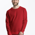 En mand iført en rød sweatshirt står smilende, med hænderne let sammenfoldet. Han har kort hår og fuldskæg. Tekst: "Neutral Certified Responsibility." Baggrunden er hvid.