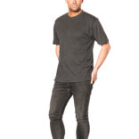 Mand står oprejst med hænderne i lommerne, iført en grå t-shirt, sorte jeans og blå sneakers, på en hvid baggrund.