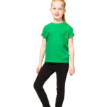 Et barn iført en grøn t-shirt og sorte bukser står og smiler i et hvidt studie.