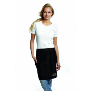 Kvinde iført hvid t-shirt og sort forklæde står afslappet; teksten på forklædet siger: "Dit Design". Hendes omgivelser er en neutral, lys baggrund.