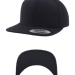 Sort kasket med flad skygge i to vinkler. Etiketten på skyggen viser “CLASSIC SNAPBACK YUPOONG” i et neutralt studieomgivelser.