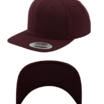 En vinrød snapback kasket vist fra to perspektiver: ovenfra og undersiden af skyggen. Tekst på klistermærket: "Classic Snapback Yupoong".
