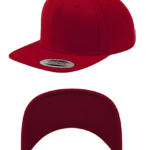 En rød snapback cap er placeret mod en hvid baggrund. Etikettekst: "CLASSIC SNAPBACK YUPOONG." Kappens underside vises også separat nedenunder.