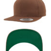 En brun baseballkasket vises fra to vinkler: ovenfra med en sølvfarvet “snapback” etiket, og nedenfra med en grøn skygge.