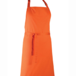 Orange forklæde hænger, set forfra. Forklædet har en nakkerem og et bindebånd omkring taljen. Baggrunden er hvid og minimalistisk.