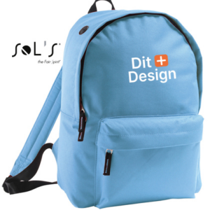 Rygsæk er lyseblå med teksten "Dit Design" trykt foran. Den har lynlåslomme og bærestrop, placeret mod en hvid baggrund. Der står "SOL'S the fair spirit" øverst.