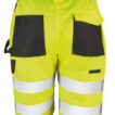Neongule shorts med reflekterende striber og sorte lommer hænger frit i luften. De er designet til sikkerhedsarbejde og har flere opbevaringslommer.