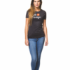Kvinde går mod kameraet, iført sort t-shirt med teksten "orbit design" og blå jeans, står på hvid baggrund.