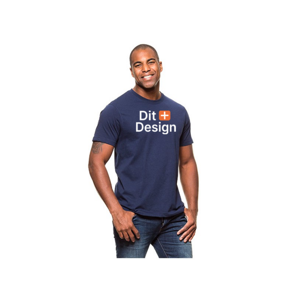 Mand bærer en mørkeblå t-shirt med teksten "Dit Design" i hvidt og et orange plus-tegn, står afslappet og smilende mod en hvid baggrund.
