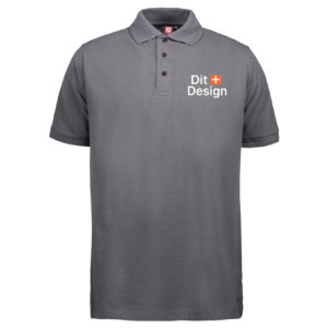 Grå poloshirt vises stående i neutrale omgivelser. Teksten "Dit Design" med et orange plustegn er trykt på venstre bryst.