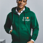 Mand i grøn hættetrøje står afslappet; trøjen har teksten "Eco Design" i hvid og orange skrift. Baggrund er enkel og neutral.