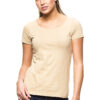 En kvinde iført en beige t-shirt og mørkeblå jeans står oprejst mod en hvid baggrund. Hun har en afslappet holdning og kigger direkte fremad.