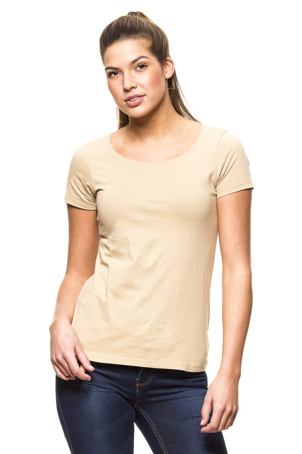 000210_Lady_Classic_06c En kvinde iført en beige t-shirt og mørkeblå jeans står oprejst mod en hvid baggrund. Hun har en afslappet holdning og kigger direkte fremad.