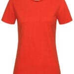 En rød T-shirt hænger frit med en rund hals og kort ærmer. Øverst er der en hvid etiket med en lille tekst. Baggrunden er ensfarvet hvid.
