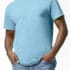 En person iført en lyseblå T-shirt står med hænderne stukket i lommerne på et par blå jeans. Baggrunden er en simpel, hvid væg.