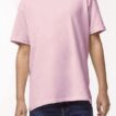 En person bærer en lyserød t-shirt og blå jeans, stående i en neutral, ensfarvet baggrund.