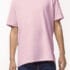 En person bærer en lyserød t-shirt og blå jeans, stående i en neutral, ensfarvet baggrund.