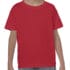 Et barn iført en rød T-shirt står stille, med hænderne ned langs siderne, iført blå jeans. Baggrunden er hvid og enkel.