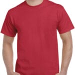 En person iklædt en enkel, rød T-shirt står med hænderne i lommerne, der ses fra taljen og op. Den omgivende baggrund er neutral og udefineret.