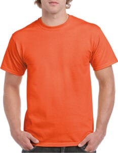 En person iført en orange t-shirt står med hænderne i bukselommerne. T-shirten er ensfarvet, og personen har kort, lyst hår. Personens ansigt er ikke fuldt synligt.