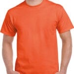 En mand iført en ensfarvet orange t-shirt står med hænderne i lommerne. Han har kort hår og bærer jeans, set mod en hvid baggrund.