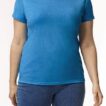 En person iført en blå t-shirt står afslappet i neutralt lys, med hænderne ved siden af kroppen og blå jeans.