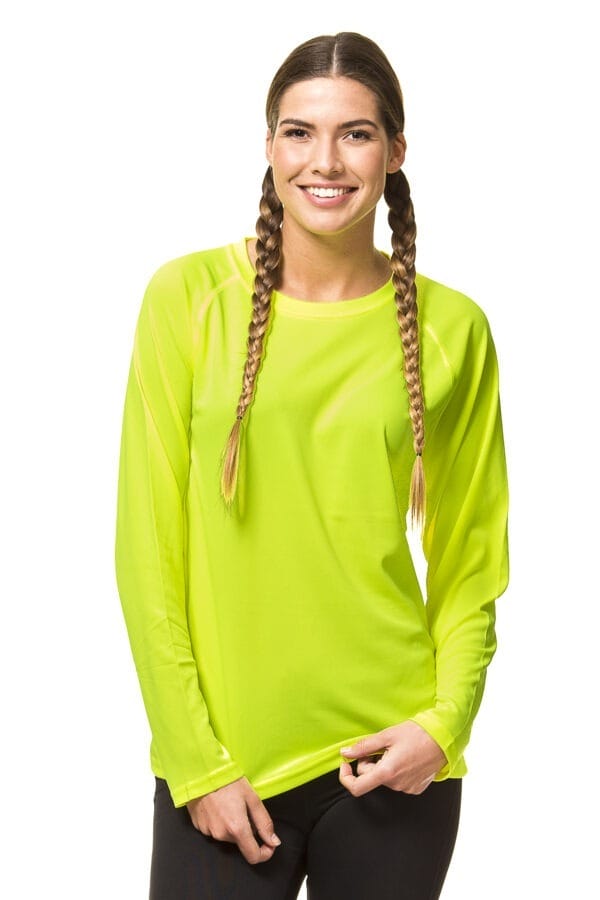 000450_Go_Sport_LS_02c En kvinde med fletninger iført en gul langærmet trøje smiler, mens hun holder bunden af trøjen. Baggrunden er hvid.