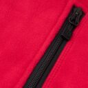 Sort lynlås, delvist åben, på en rød fleecejakke.