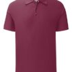 En vinrød poloshirt hænger i en neutral studiebelysning. Skjorten har korte ærmer og tre knapper ved halsen.